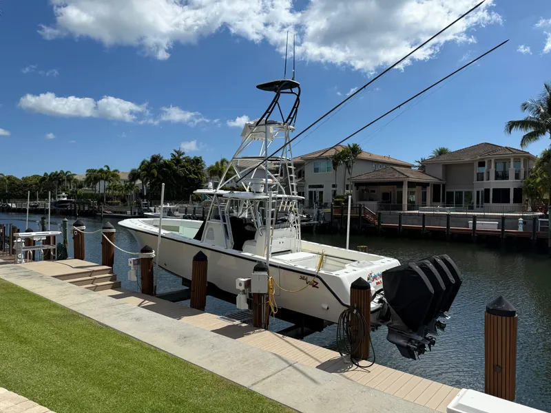 Slide: The Image of 2018 SeaVee 390Z boat docked by waterfront homes under a clear blue sky. - 11