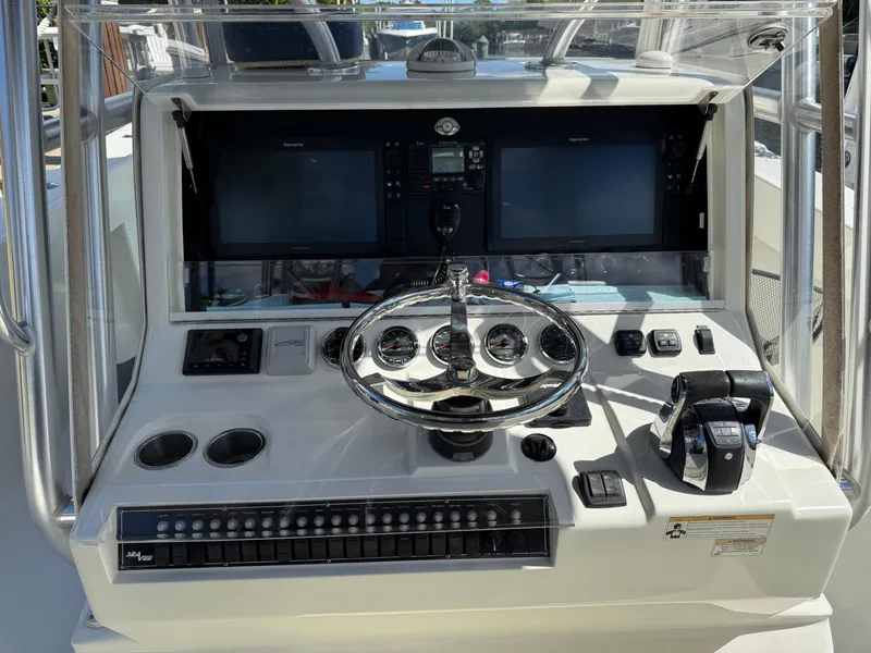 Slide: The Image of Control panel of a 2018 SeaVee 390Z boat with steering wheel and navigation screens. - 13