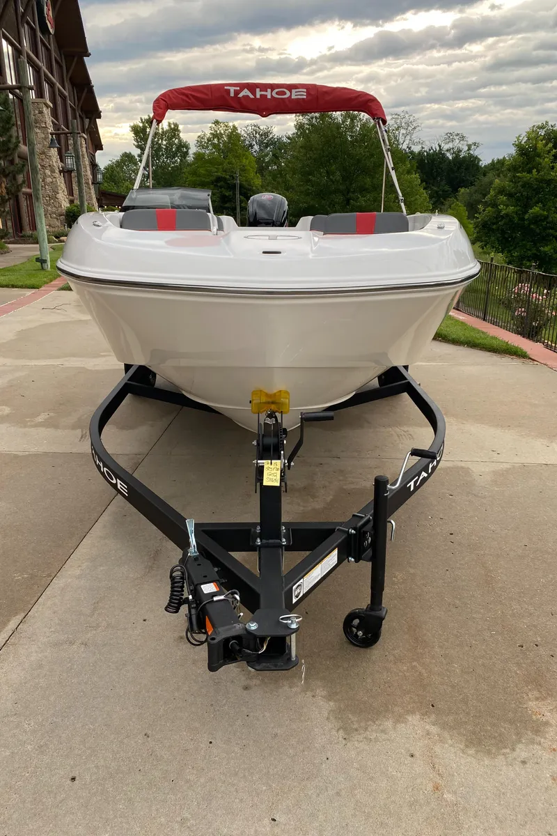 Slide: The Image of 2025 Tahoe T18 boat on trailer, parked outdoors with overcast sky. - 2