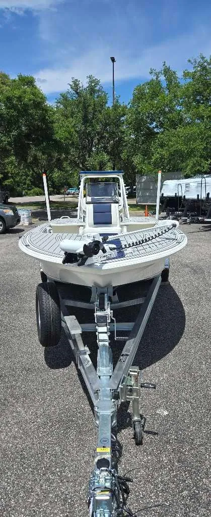 Slide: The Image of 2025 Mako 18 Pro Skiff Patriot Edition on trailer, parked outdoors. - 1