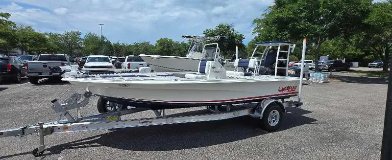 Slide: The Image of 2025 Mako 18 Pro Skiff Patriot Edition boat on trailer in parking lot. - 3