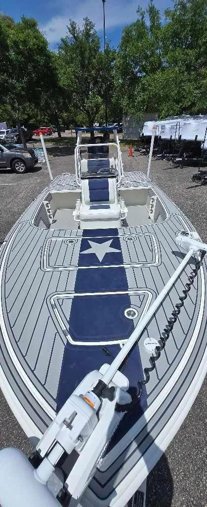 Slide: The Image of 2025 Mako 18 Pro Skiff Patriot Edition boat with star design, parked outdoors. - 4