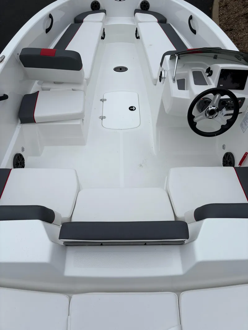 Slide: The Image of 2025 Tahoe T18 boat interior with white and gray seating, steering wheel, and dashboard. - 2
