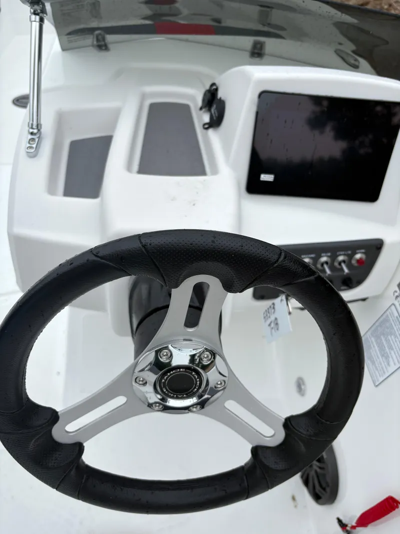 Slide: The Image of Steering wheel and dashboard of 2025 Tahoe T18 boat, featuring modern controls and display. - 4