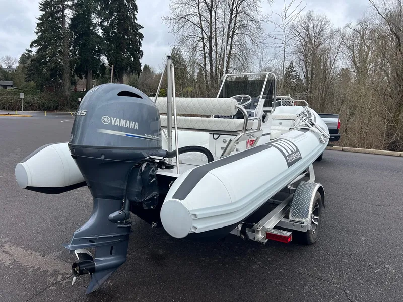 Slide: The Image of 2024 Novurania DL 550 boat with Yamaha engine on a trailer, parked outdoors. - 2