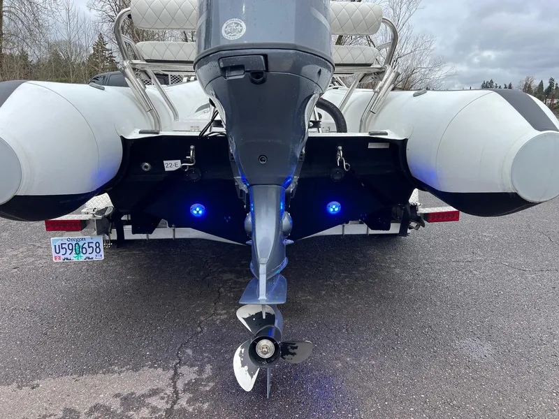 Slide: The Image of 2024 Novurania DL 550 boat rear view with outboard motor and blue lights. - 26