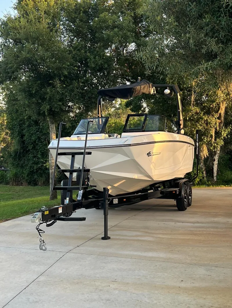 Slide: The Image of 2022 Nautique Super Air G23 boat on trailer, parked outdoors. - 0