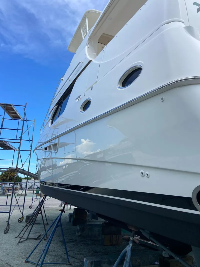 Slide: The Image of 1999 Silverton 453 Motor Yacht on dry dock with scaffolding under clear blue sky. - 11