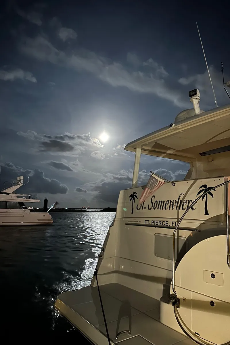 Slide: The Image of 1999 Silverton 453 Motor Yacht under moonlit sky at marina. - 16