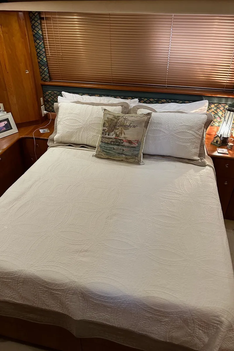 Slide: The Image of 1999 Silverton 453 Motor Yacht bedroom with white bedding and decorative pillows. - 18
