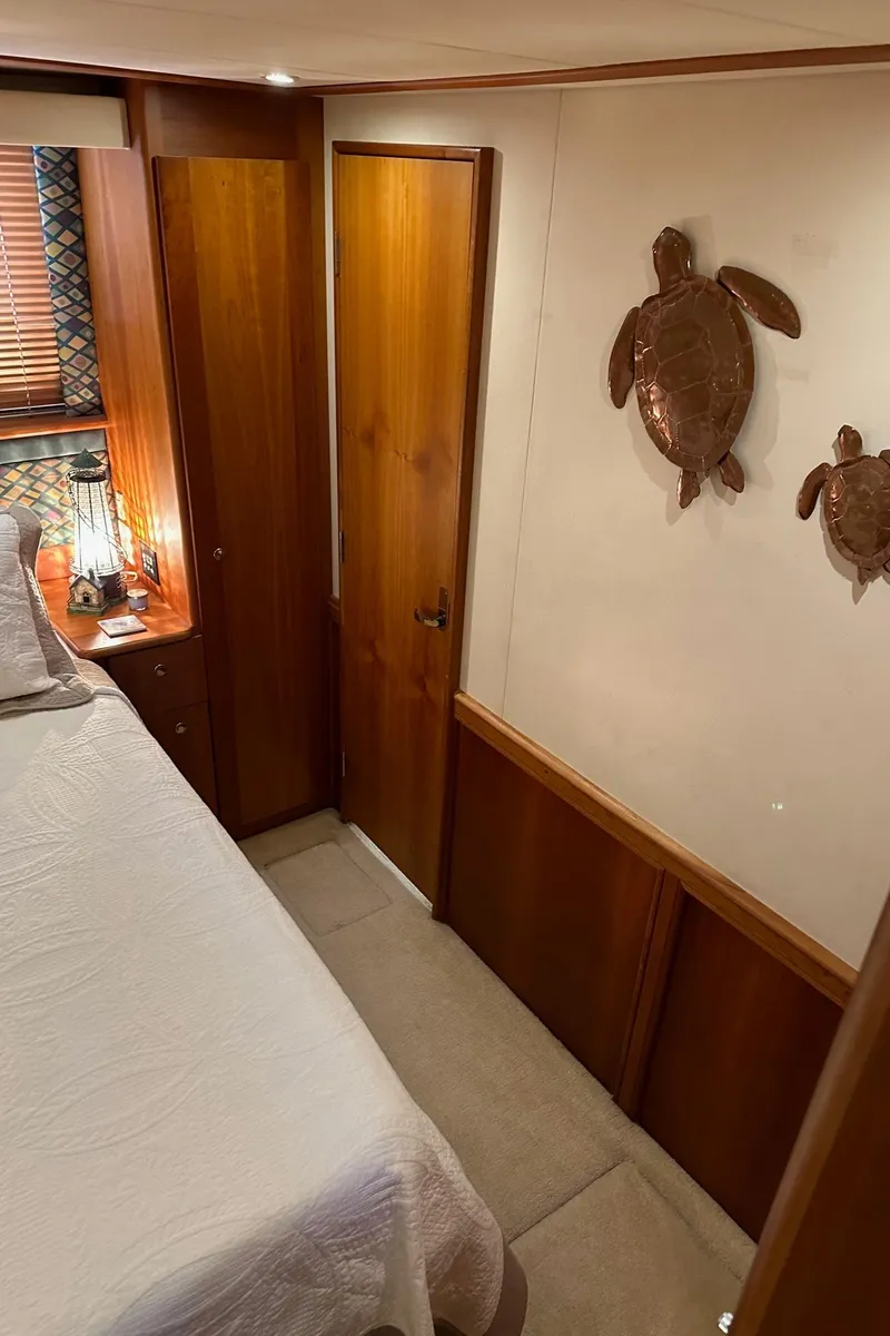 Slide: The Image of 1999 Silverton 453 Motor Yacht interior with wooden decor and turtle wall art. - 19