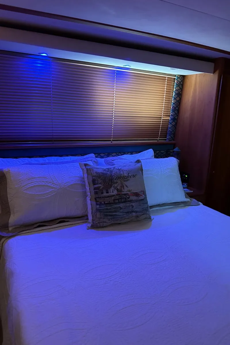 Slide: The Image of Interior of 1999 Silverton 453 Motor Yacht bedroom with cozy bedding and ambient lighting. - 21