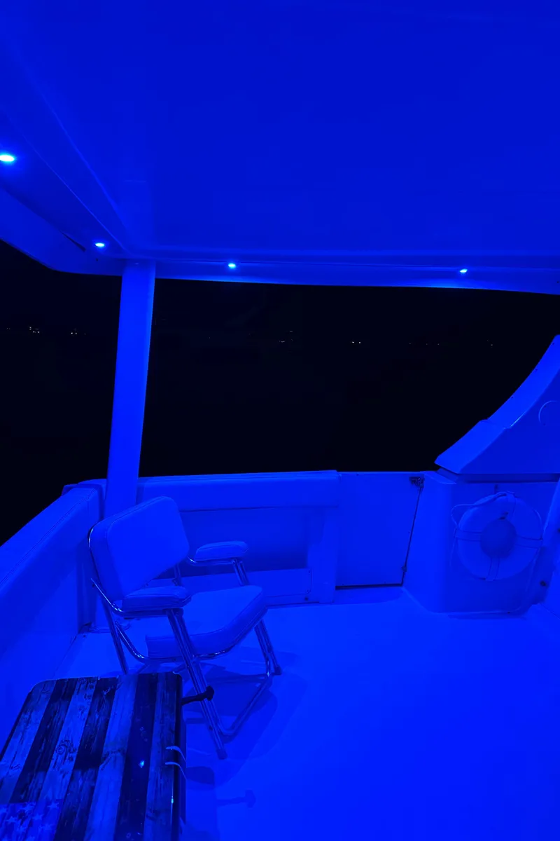 Slide: The Image of 1999 Silverton 453 Motor Yacht deck illuminated with blue LED lights at night. - 23