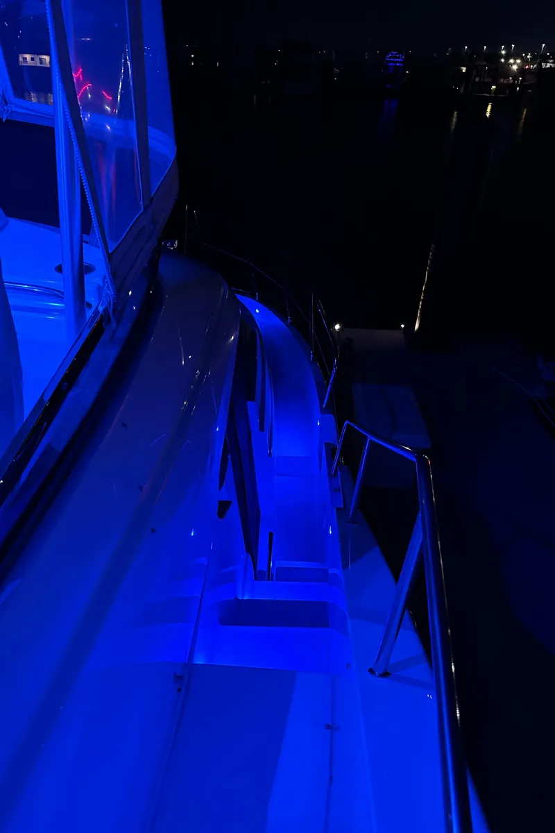 Slide: The Image of 1999 Silverton 453 Motor Yacht illuminated with blue lights at night. - 26