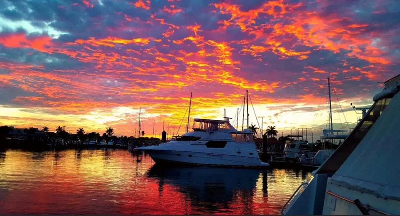 Slide: The Image of Silverton 453 Motor Yacht at sunset, vibrant sky reflecting on calm water, 1999 model. - 3