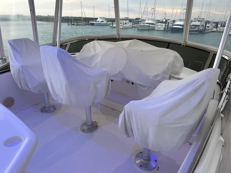 Slide: The Image of 1999 Silverton 453 Motor Yacht interior with covered seats, docked at marina. - 42