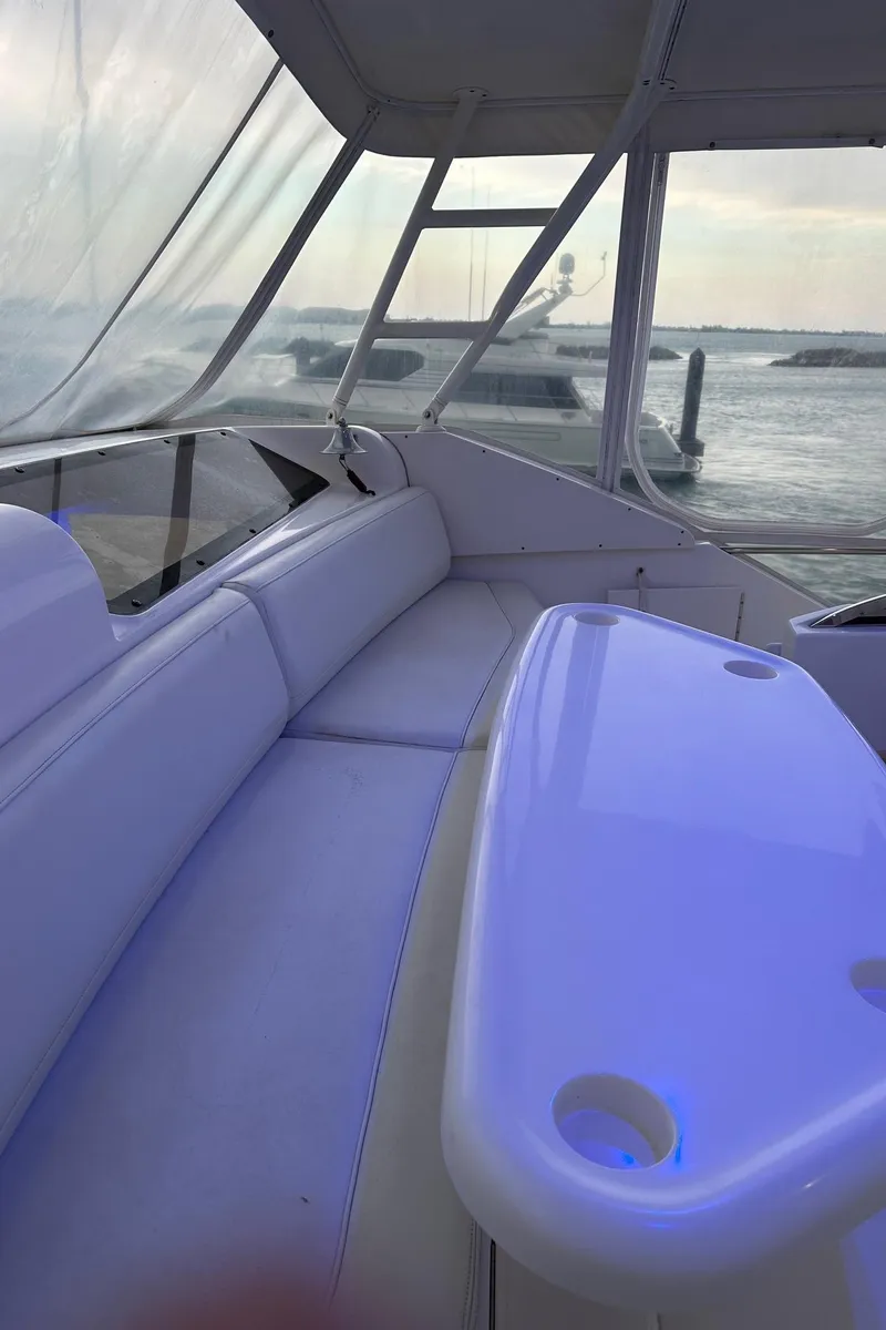 Slide: The Image of 1999 Silverton 453 Motor Yacht interior with seating and table, overlooking marina. - 47