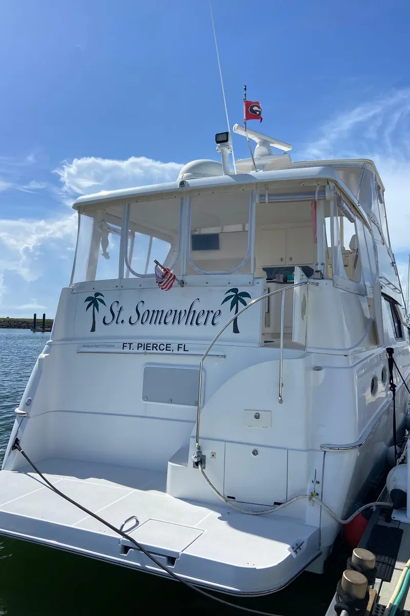Slide: The Image of 1999 Silverton 453 Motor Yacht docked, featuring "St. Somewhere" and palm tree graphics. - 9