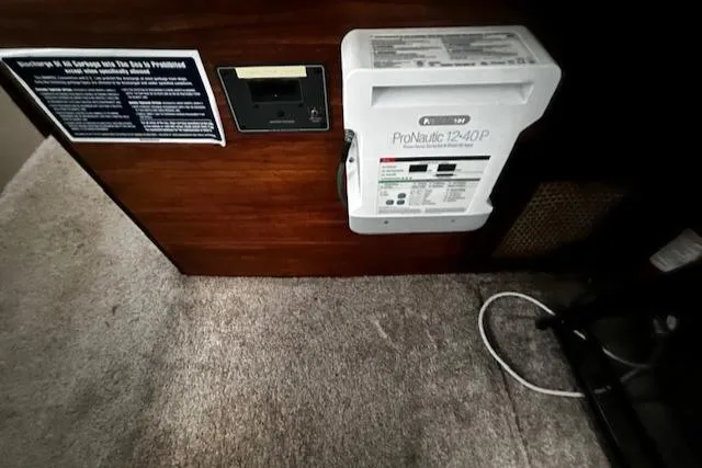 Slide: The Image of 1985 Bayliner 3870 Motoryacht interior showing electrical panel and carpeted floor. - 13