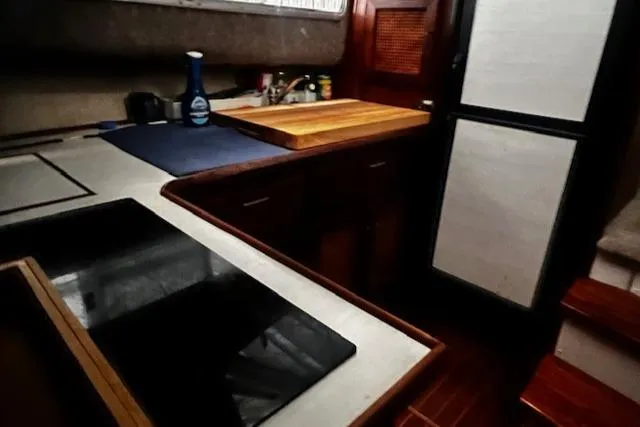 Slide: The Image of 1985 Bayliner 3870 Motoryacht kitchen with stove, cutting board, and refrigerator. - 18