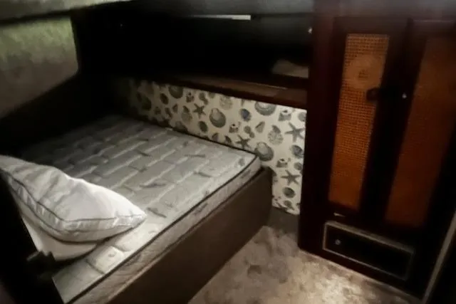 Slide: The Image of 1985 Bayliner 3870 Motoryacht cabin interior with bed and patterned wall. - 21