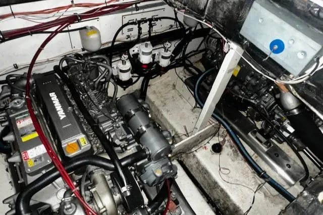 Slide: The Image of Engine room of 1985 Bayliner 3870 Motoryacht with Flybridge, showcasing mechanical components and wiring. - 23