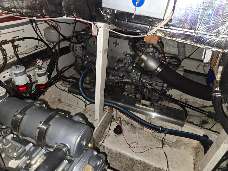 Slide: The Image of Engine room of 1985 Bayliner 3870 Motoryacht, showcasing mechanical components and wiring. - 24