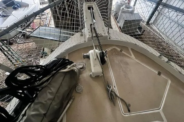 Slide: The Image of 1985 Bayliner 3870 Motoryacht bow with anchor chain and winch, docked in a covered area. - 28