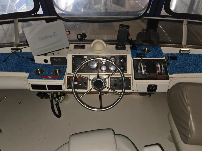 Slide: The Image of 1985 Bayliner 3870 Motoryacht flybridge helm with Garmin navigation and classic steering wheel. - 34