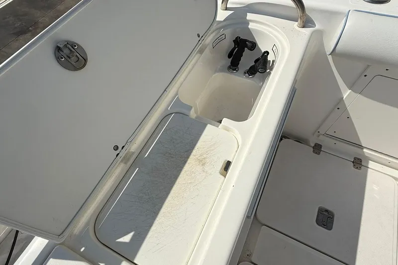 Slide: The Image of 2006 Century 3200 Center Console boat storage compartment with open lid and clean interior. - 17