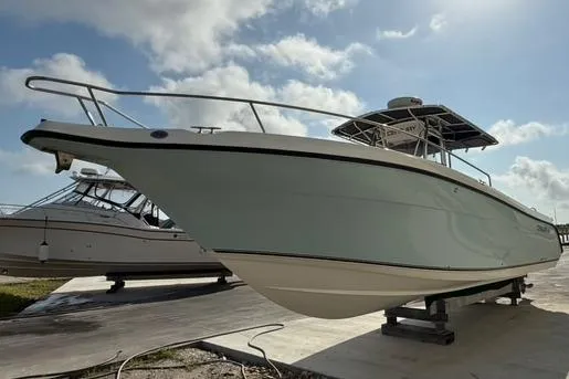 Slide: The Image of 2006 Century 3200 Center Console boat on a dock under a cloudy sky. - 4