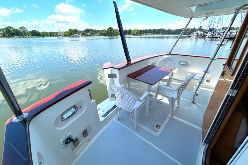 Slide: The Image of 1999 Selene 43 yacht deck with table, chairs, and scenic waterfront view. - 11