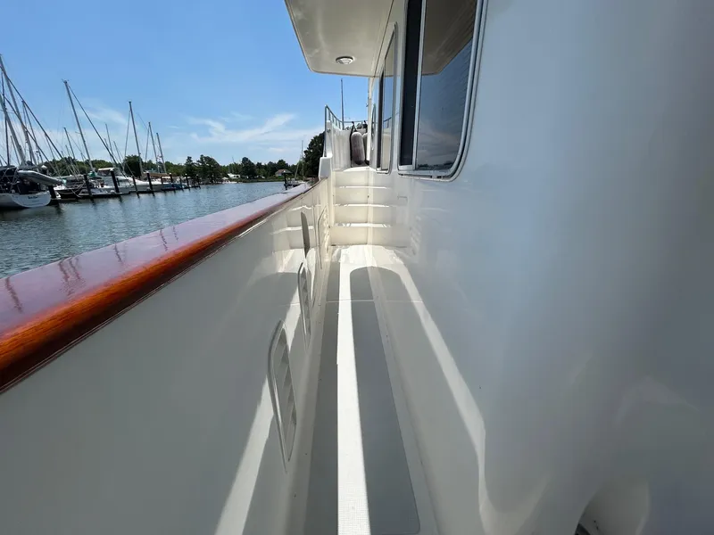 Slide: The Image of Side deck of 1999 Selene 43 yacht with polished wood railing, docked at marina. - 14