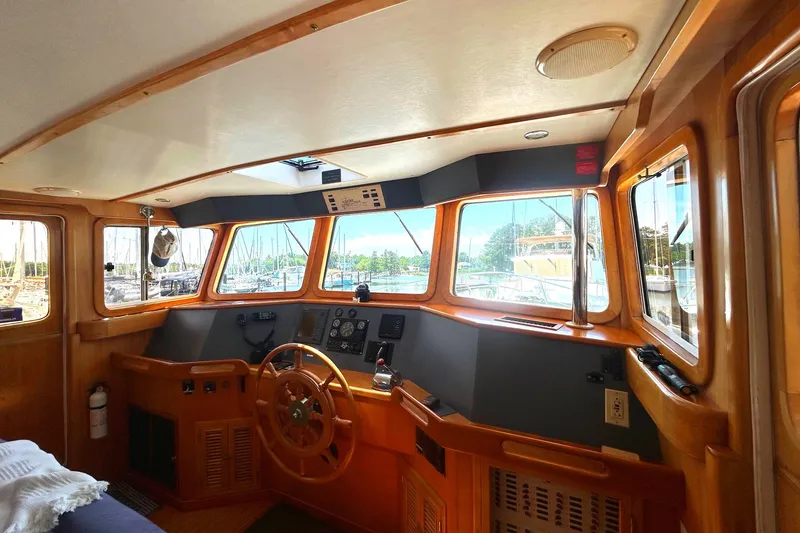 Slide: The Image of Interior view of 1999 Selene 43 boat cockpit with wooden steering wheel and navigation controls. - 18
