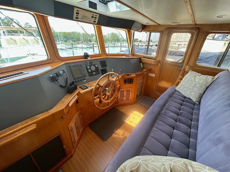 Slide: The Image of Interior of 1999 Selene 43 yacht with wooden helm, plush seating, and navigation equipment. - 19