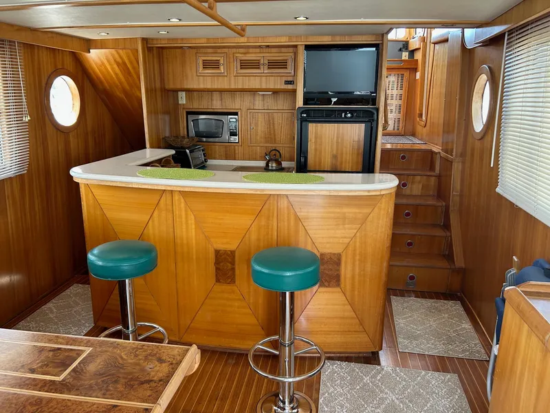 Slide: The Image of Interior of 1999 Selene 43 yacht with wooden bar, stools, and kitchen appliances. - 23
