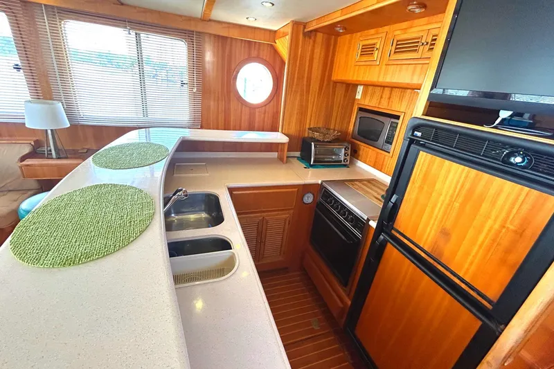 Slide: The Image of Luxurious Selene 43 yacht kitchen interior, featuring wood cabinetry, modern appliances, and ample counter space. - 25