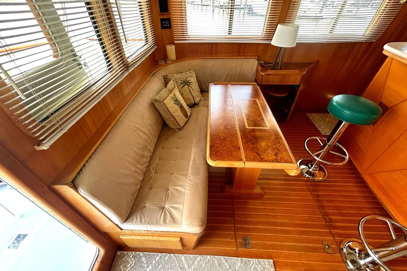 Slide: The Image of Luxurious Selene 43 yacht interior with wooden table, cushioned seating, and bar stools, 1999 model. - 27