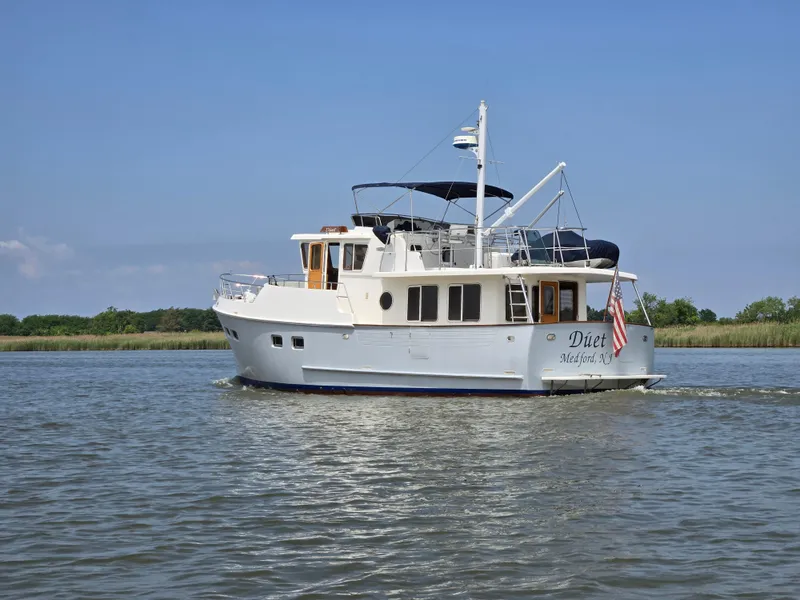 Slide: The Image of Selene 43 yacht cruising on a calm river, 1999 model, with clear skies. - 3
