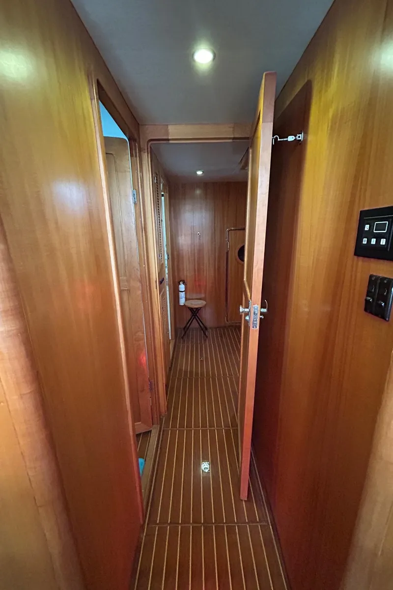 Slide: The Image of Wood-paneled hallway inside 1999 Selene 43 yacht, featuring polished flooring and modern lighting. - 39