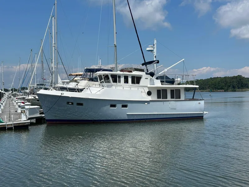 Slide: The Image of Selene 43 yacht from 1999 docked in a marina under a clear blue sky. - 4