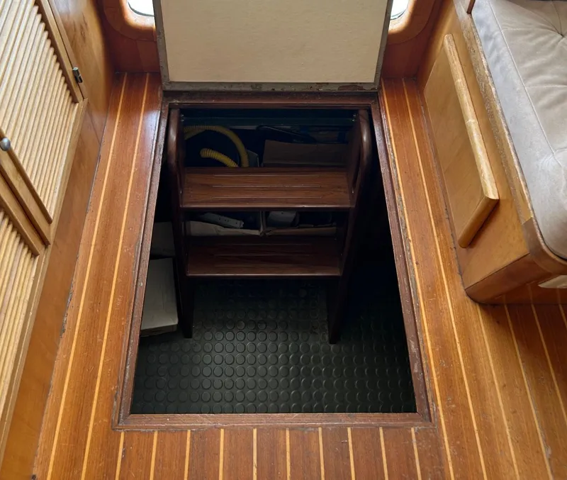 Slide: The Image of Wooden hatch with steps leading to storage in a 1999 Selene 43 boat interior. - 42