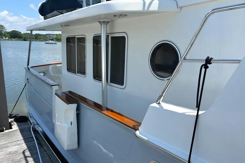 Slide: The Image of Side view of a 1999 Selene 43 yacht docked by a calm lake. - 7
