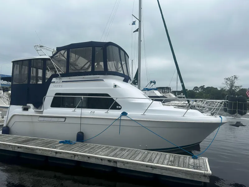 Slide: The Image of 1997 Mainship 34' M/Y yacht docked at marina with overcast sky. - 0