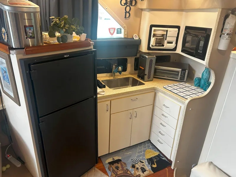 Slide: The Image of Compact kitchen in a 1997 Mainship 34' M/Y boat with appliances and storage. - 13