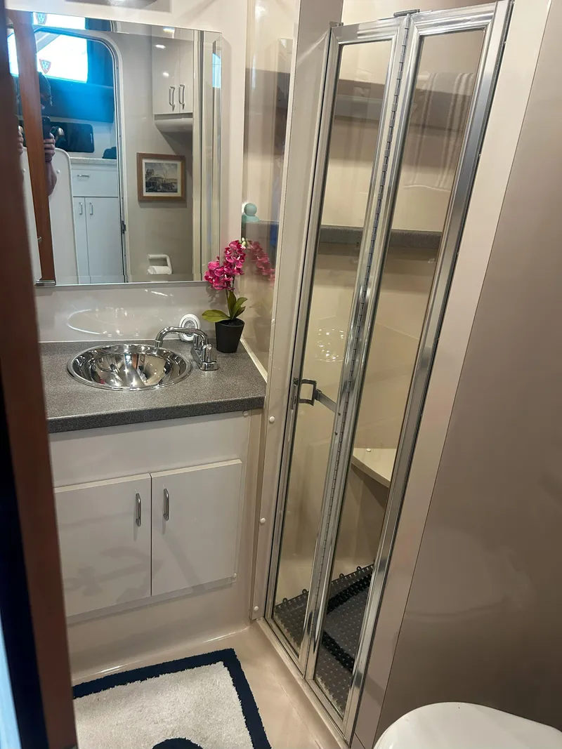 Slide: The Image of Bathroom interior of a 1997 Mainship 34' M/Y yacht with sink and shower. - 14