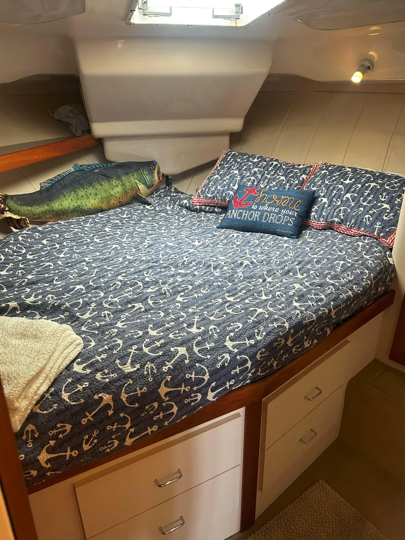 Slide: The Image of 1997 Mainship 34' M/Y cabin with anchor-themed bedding and decorative pillows. - 15