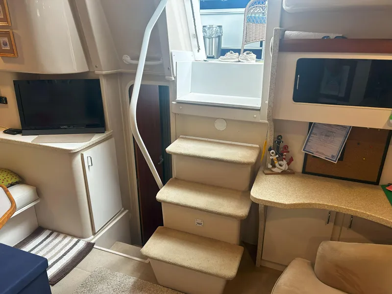 Slide: The Image of Interior of 1997 Mainship 34' M/Y yacht with stairs, TV, and desk area. - 16