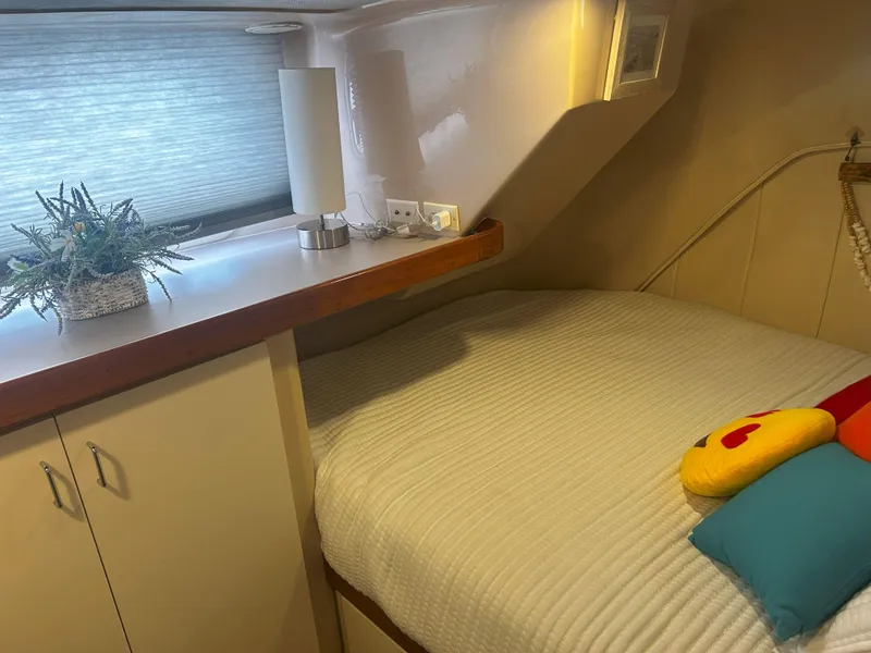 Slide: The Image of Cozy cabin interior of 1997 Mainship 34' M/Y with bed and decorative pillows. - 17