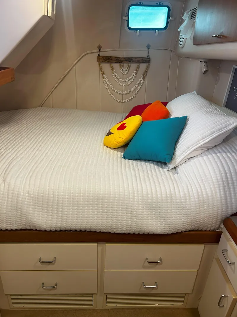 Slide: The Image of Cozy cabin interior of 1997 Mainship 34' M/Y with colorful pillows and white bedding. - 18